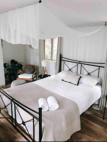 a bedroom with a large white bed with two pillows at Earthly Retreat - Private Noosa Hinterland Getaway in Doonan