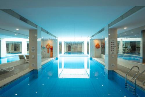 a large swimming pool with blue water in a building at Tonino Lamborghini Hotel Suzhou in Suzhou