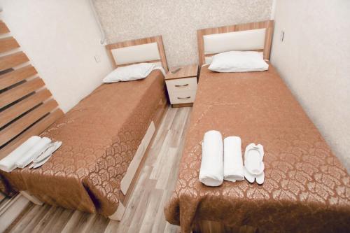 two beds in a room with slippers on the floor at N butik Hotel in Ganja