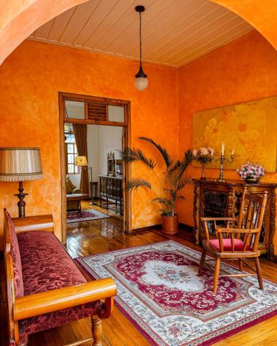 an orange living room with a couch and a fireplace at Hotel Boutique Casa Montalvo Cuenca in Cuenca