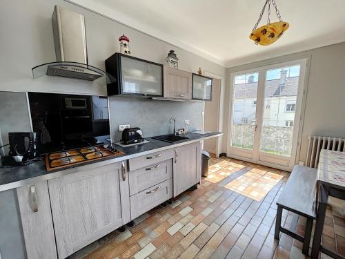 une cuisine avec un évier et une cuisinière dans l'établissement Maison avec jardin près de la mer - FR-1-361-560, à Donville-les-Bains