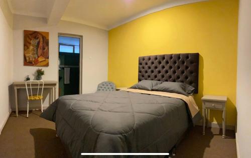 a bedroom with a bed and a yellow wall at Templo de la Luna in Cusco