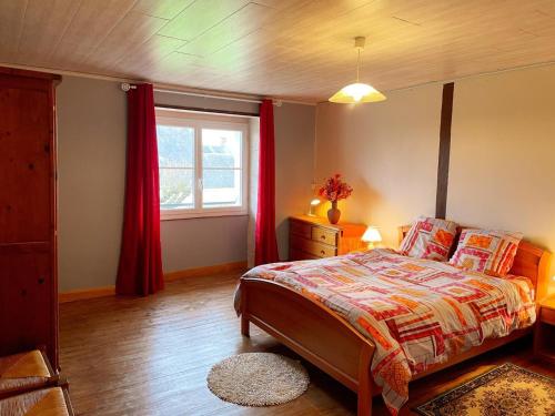 une chambre avec un lit avec des rideaux rouges et une fenêtre dans l'établissement Gîte chaleureux avec sauna, près des châteaux de la Loire - FR-1-491-456, à Pouillé