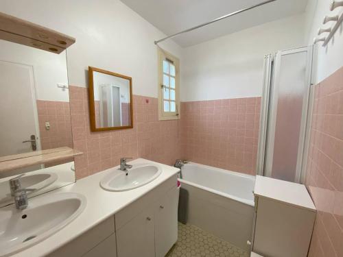 une salle de bain avec deux lavabos et une baignoire dans l'établissement Maison avec jardin à 450m de la mer à Trégastel - FR-1-368-453, à Trégastel