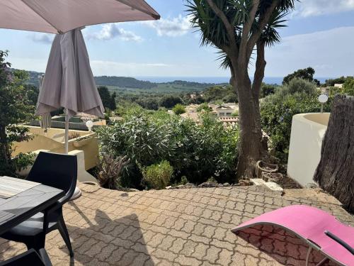 un patio avec une table et un parasol dans l'établissement Mas climatisé avec piscine et vue mer à La Croix-Valmer - FR-1-726-54, à La Croix-Valmer