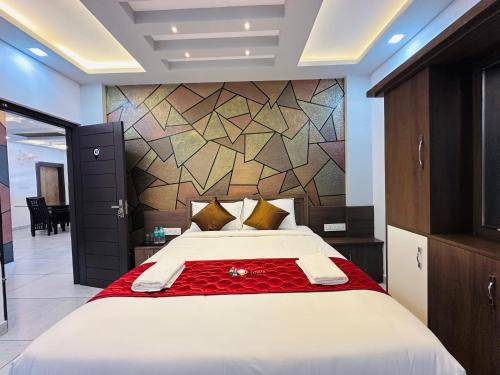 a bedroom with a large white bed and a wall at Crystal Winter Arcade wayanad in Wayanad