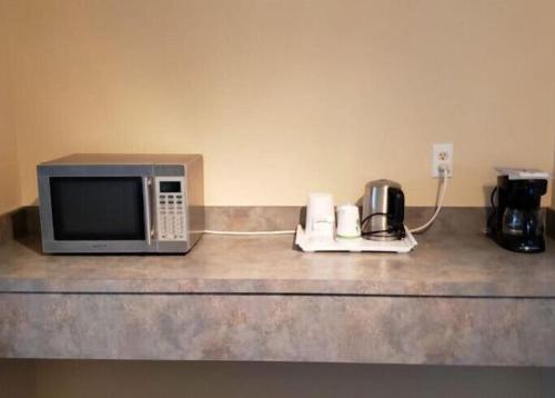 a microwave sitting on top of a kitchen counter at Elite Hotel -Downtown Center- "Ski & Northern light Tour" "Hot Spring Tour "Long-term stay" in Whitehorse