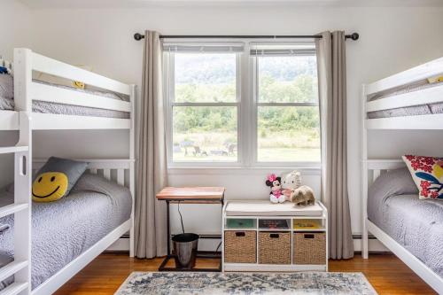 a room with two bunk beds and a window at The Yuzu stunning mountain retreat with hot tub in Gardiner