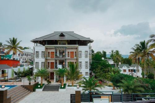 a large white building with palm trees in front of it at Crystal Winter Arcade wayanad in Wayanad