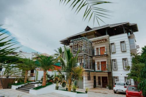 a building with palm trees in front of it at Crystal Winter Arcade wayanad in Wayanad