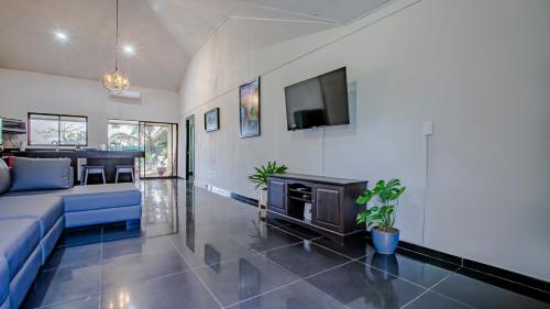 a living room with a blue couch and a tv at Anthurium house in Fortuna