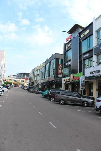 a city street with cars parked in front of buildings at ORO Hotel Kluang in Kluang