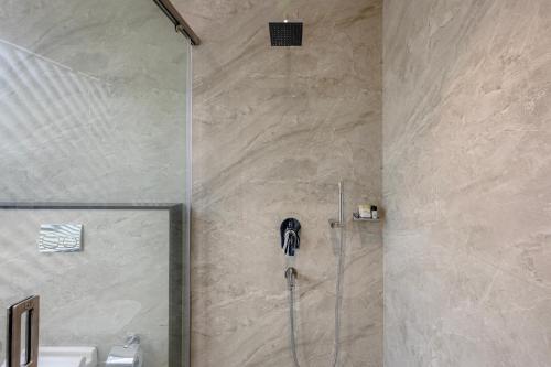 a bathroom with a shower with a shower head at Maple Comfort in Visakhapatnam