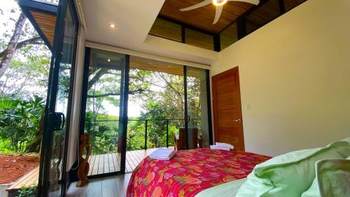 a bedroom with a bed and a large window at Casita Jungle Nest, 5 minutes drive to Playa Linda, 15 to Dominical, Wifi Starlink in Matapalo