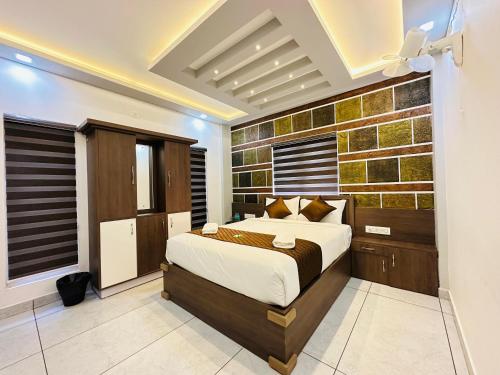 a bedroom with a king sized bed and a brick wall at Crystal Winter Arcade wayanad in Wayanad