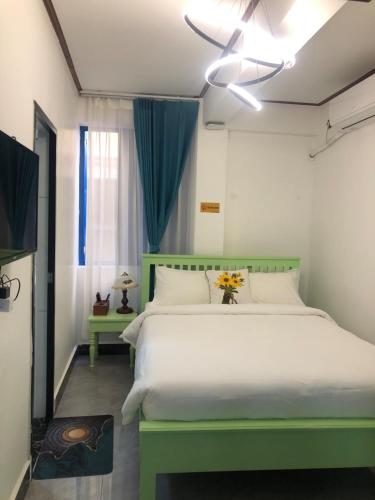 a bedroom with a large white bed with a green headboard at Vip KINGSON GUEST HOUSE in Luang Prabang