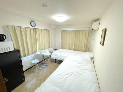 a hospital room with two beds and a table at Docaホテル セルフチェックイン in Fukuoka