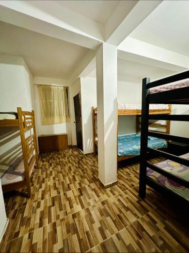 a room with three bunk beds in a dorm at Hotel shalom taganga in Taganga