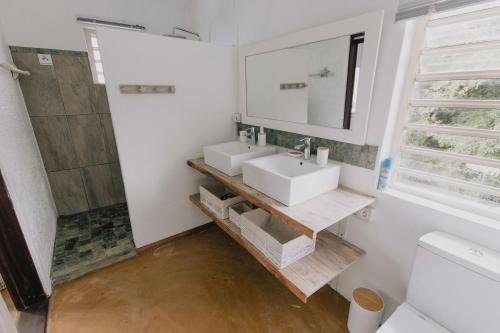 a bathroom with two sinks and a shower at Villla NOULAKAZ in Port Mathurin