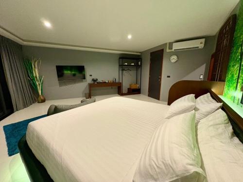 a bedroom with a large white bed in a room at Chainam-Charmchuree residences cafe and spa in Ban Bang Bua Thong