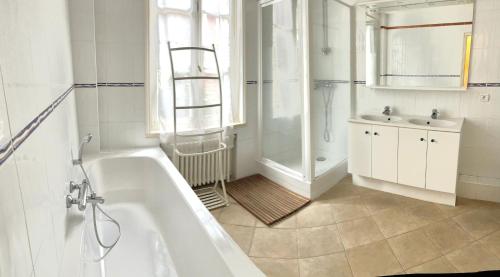 une salle de bain blanche avec une baignoire et un lavabo dans l'établissement Charmante Maison Pêcheurs, 141 m2, à Trouville-sur-Mer