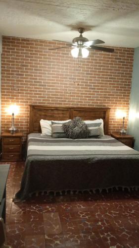 a bedroom with a large bed with a brick wall at Studio Oaxaca Centro in Oaxaca City