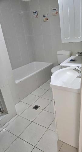 a white bathroom with a tub and a sink at Oceanfront 24th Floor 1 Bedroom Retreat with Stunning Views & Free Parking in Gold Coast