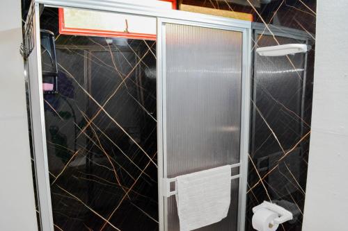 a shower stall in a bathroom with black tiles at El encanto de Ráquira in La Candelaria