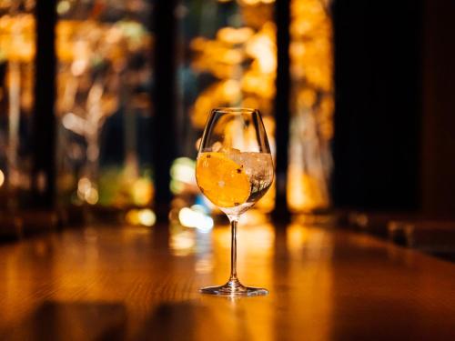 a glass of wine sitting on a wooden table at Mercure Hida Takayama in Takayama