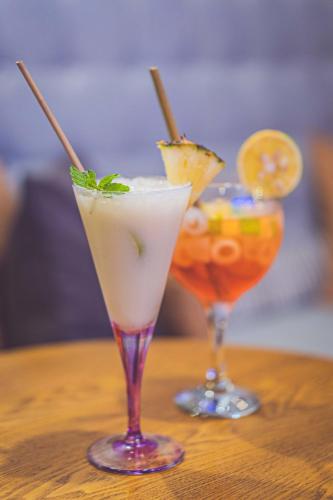 two cocktails sitting on top of a wooden table at Palissandre ANTANANARIVO in Antananarivo