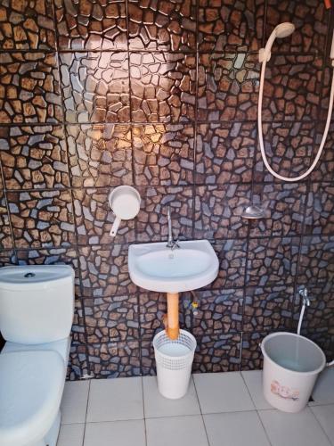 a bathroom with a toilet and a sink and a shower at Seabreeze Beachfront Home and Cottages new management in San Juan