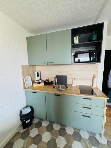 une cuisine avec un évier et un micro-ondes dans l'établissement studio calais côte d'opale, à Calais