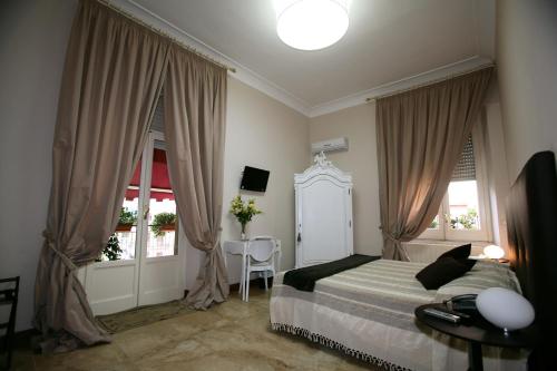 a bedroom with a bed and a table and two windows at B&B Milu' in Crotone