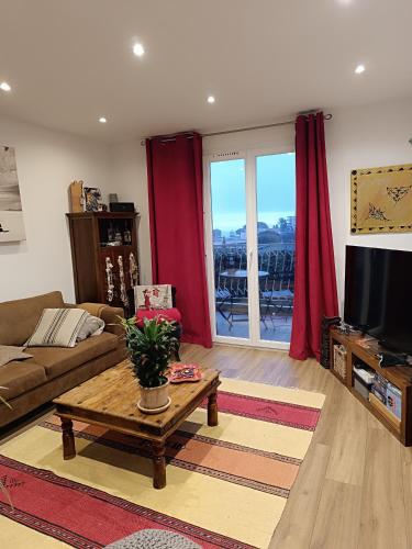 un salon avec un canapé et une télévision dans l'établissement Super deux pièces vue mer, à Nice