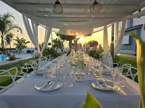 a long white table with plates and glasses on it at Kasparis View Residence in Pano Lefkara