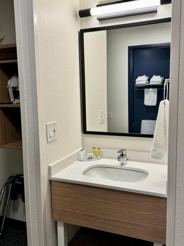 ein Badezimmer mit Waschbecken und großem Spiegel in der Unterkunft Spark by Hilton Springfield Eugene in Eugene