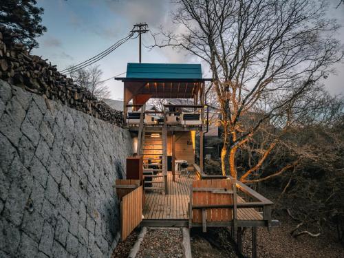 a tree house with a deck and a wall at RENEST in Kobe