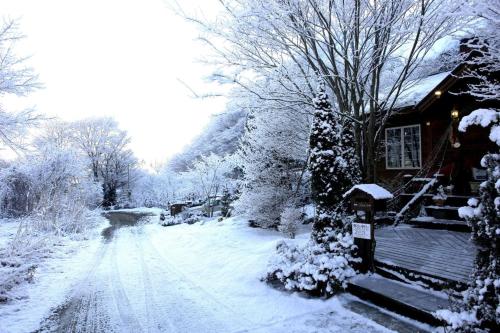 a house covered in snow next to a snow covered road at クースクース in Fujikawaguchiko