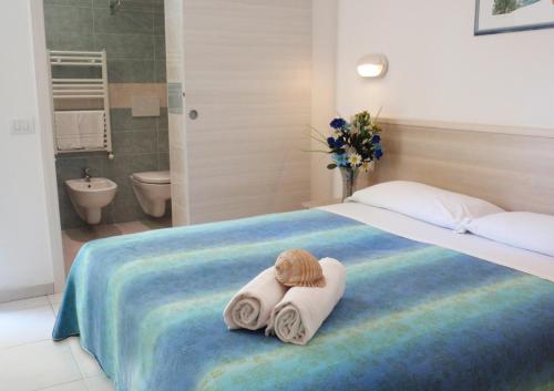 ein Hotelzimmer mit Handtüchern auf einem Bett in der Unterkunft Hotel Lara in Riccione