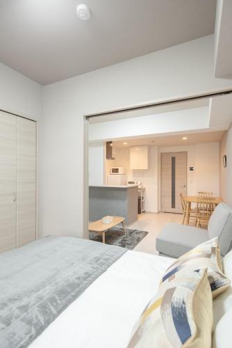 a bedroom with a bed and a living room at Hie Apartment in Fukuoka