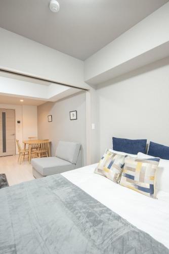 a bedroom with a bed and a living room at Hie Apartment in Fukuoka