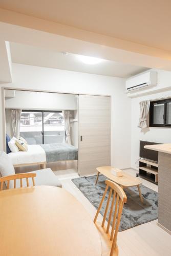 a bedroom with two beds and a living room at Hie Apartment in Fukuoka