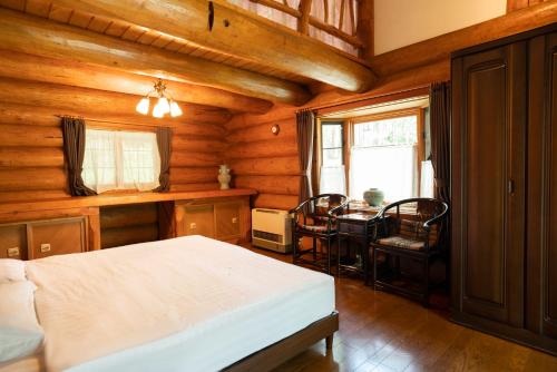 a bedroom with a bed and a table and a window at クースクース in Fujikawaguchiko