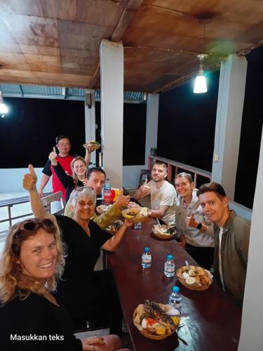 a group of people sitting around a table eating food at Talaga Tomohon Home Stay and Fishing Pond in Tomohon