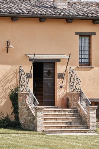 a house with a brown door and stairs in front at Borgo Lanciano in Castelraimondo