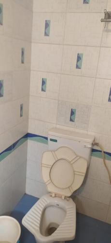 a bathroom with a white toilet in a room at Altaf's motel in Matheran