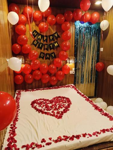 a cake with a heart on top of it with balloons at Altaf's motel in Matheran