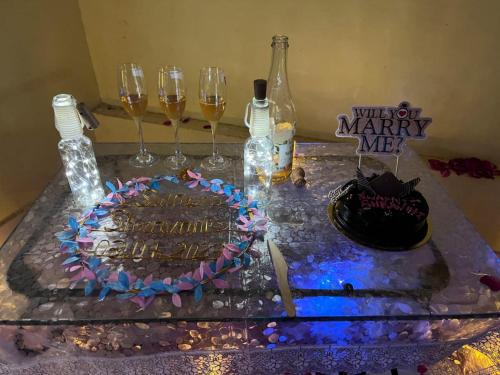 a table with a cake and wine glasses on it at Altaf's motel in Matheran