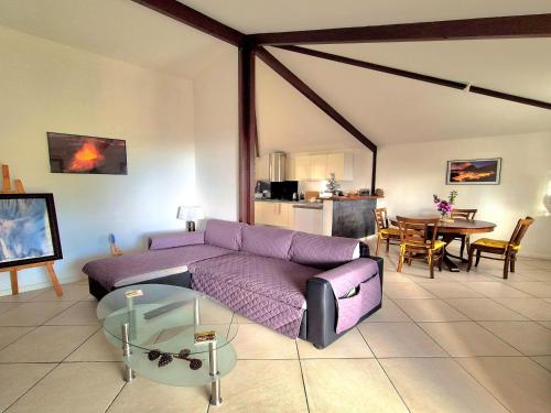 Una sala de estar con un sofá morado y una mesa. en Maison Hibiscus, en Saint-Joseph
