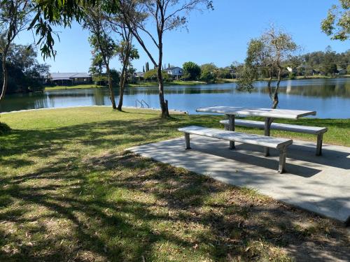 a picnic table in a park next to a lake at Lakeside Stays Yamba 1-2 small Pet Friendly in Yamba